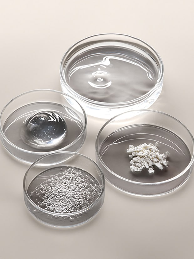 Close up of multivitamin ingredients in petri dishes on a light background with bright lighting